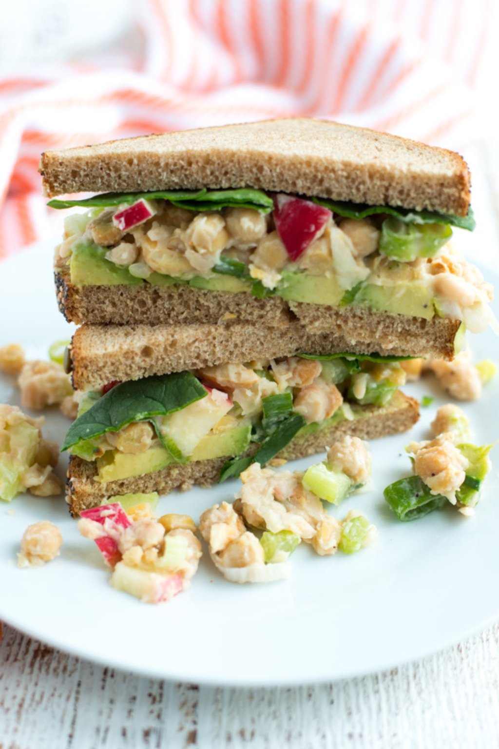 Two halves of a sandwich filled with chickpeas and vegetables.