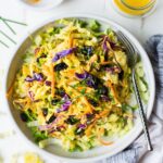 Overhead shot of turmeric chicken salad with vegetables on a white background.