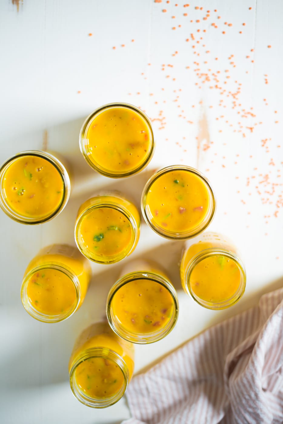 Mason jars filled with red lentil soup.