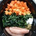 black crockpot with sweet potatoes kale and chicken breasts