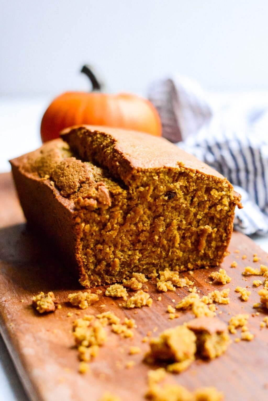 close up of a cut loaf of gluten free pumpkin bread on wooden cutting board