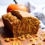 close up of a cut loaf of gluten free pumpkin bread on wooden cutting board