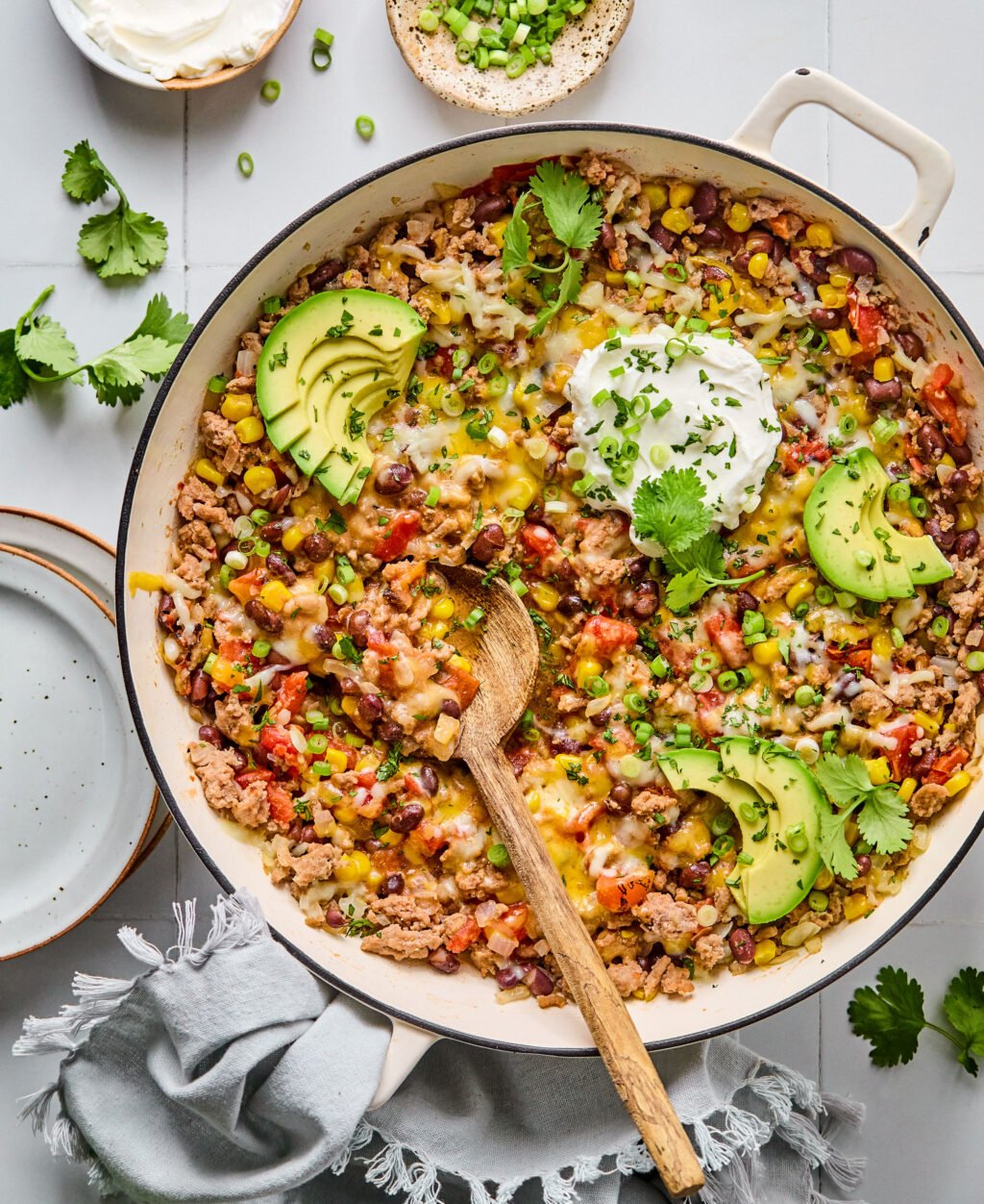 A large skillet filled with avocado, ground turkey, and chopped vegetables.
