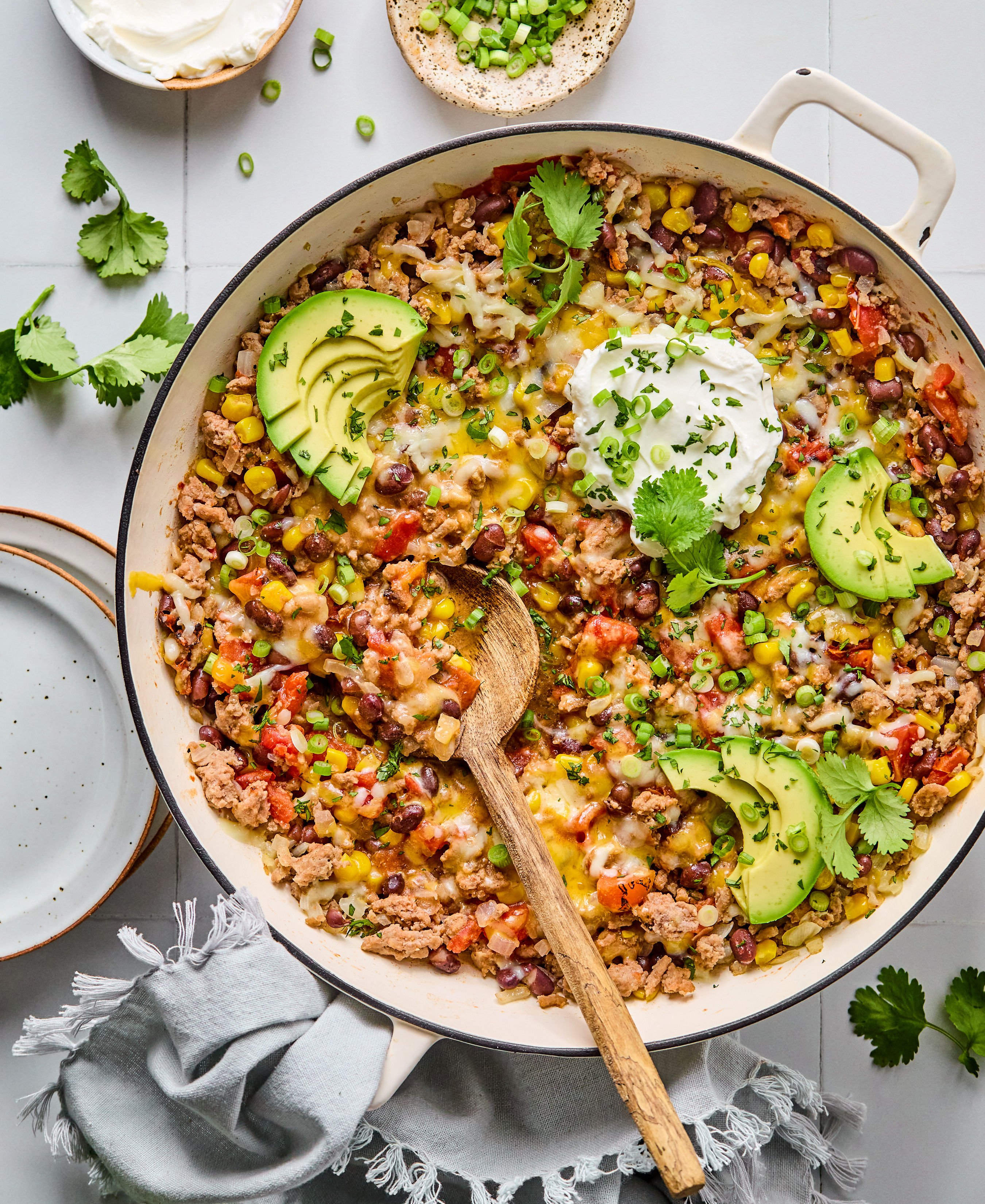 A large skillet filled with avocado, ground turkey, and chopped vegetables.