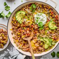A skillet filled with beans, corn, ground turkey, avocado, and bell peppers.