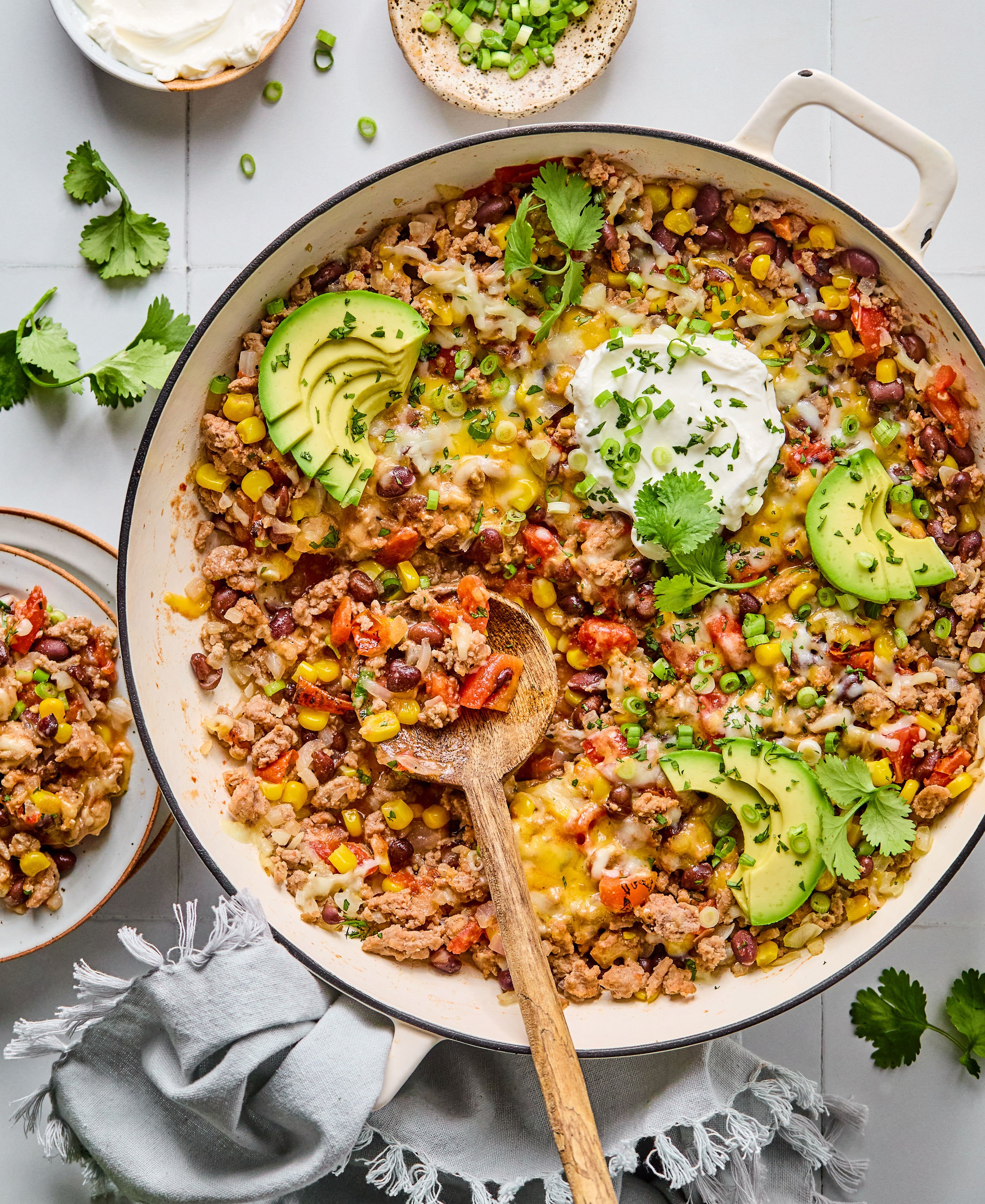 A skillet filled with beans, corn, ground turkey, avocado, and bell peppers.