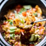 Serving spoon scooping taco casserole out of a slow cooker.