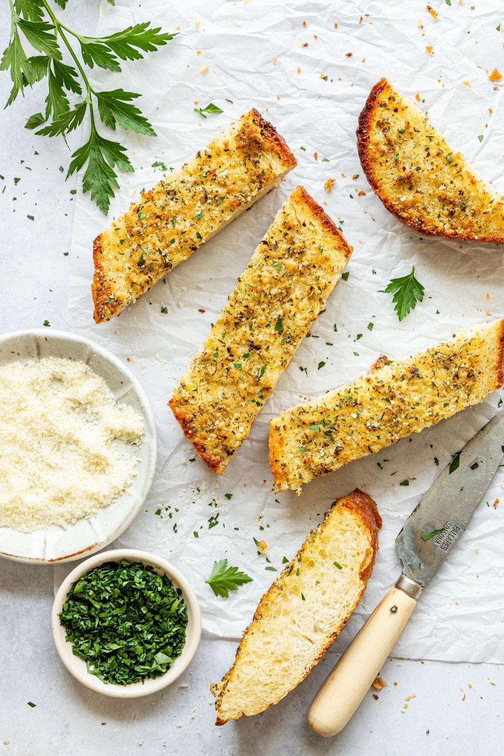 Overhead shot of slices of garlic bread on parchment paper.