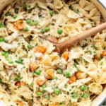 Close up overhead shot of a wooden spoon scooping pasta out of a pot.