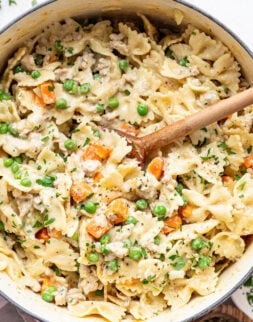 Close up overhead shot of a wooden spoon scooping pasta out of a pot.