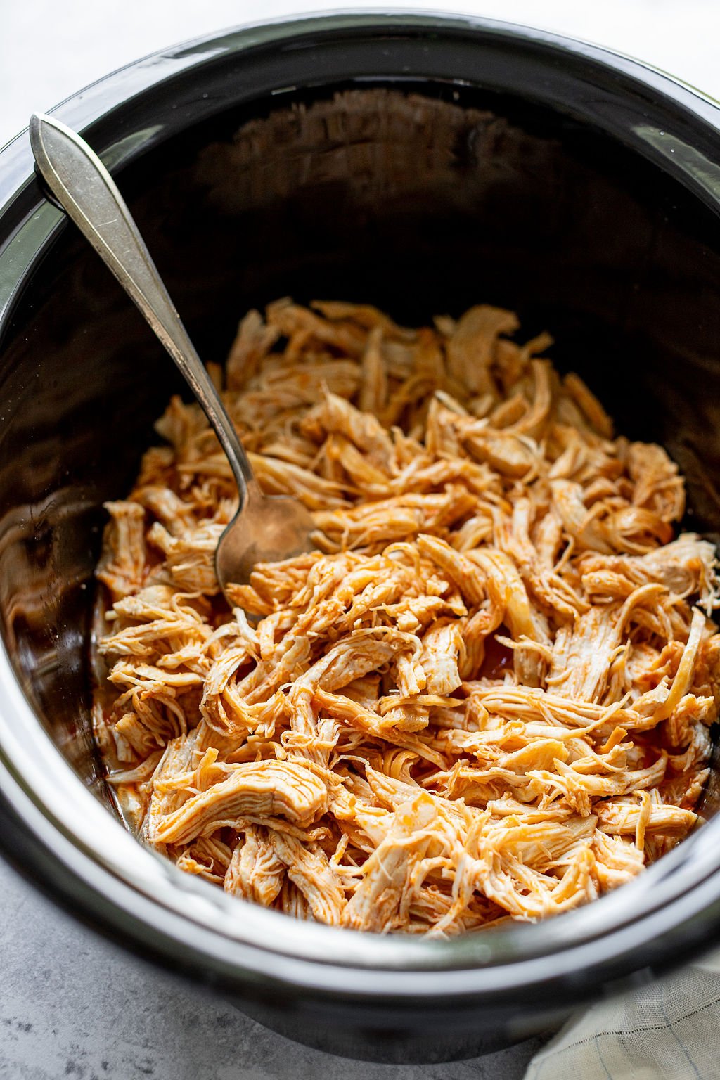 Angles shot of a slow cooker with shredded chicken.