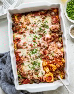 Melted cheese on pasta with beef and tomato sauce.