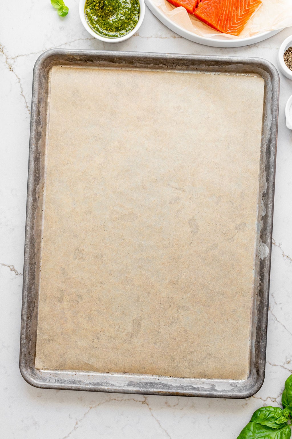 A baking sheet lined with parchment paper on a table.