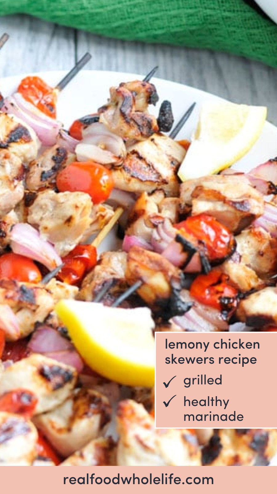 A plate of grilled chicken skewers with lemon wedges. Text that reads "lemony chicken skewers recipe."
