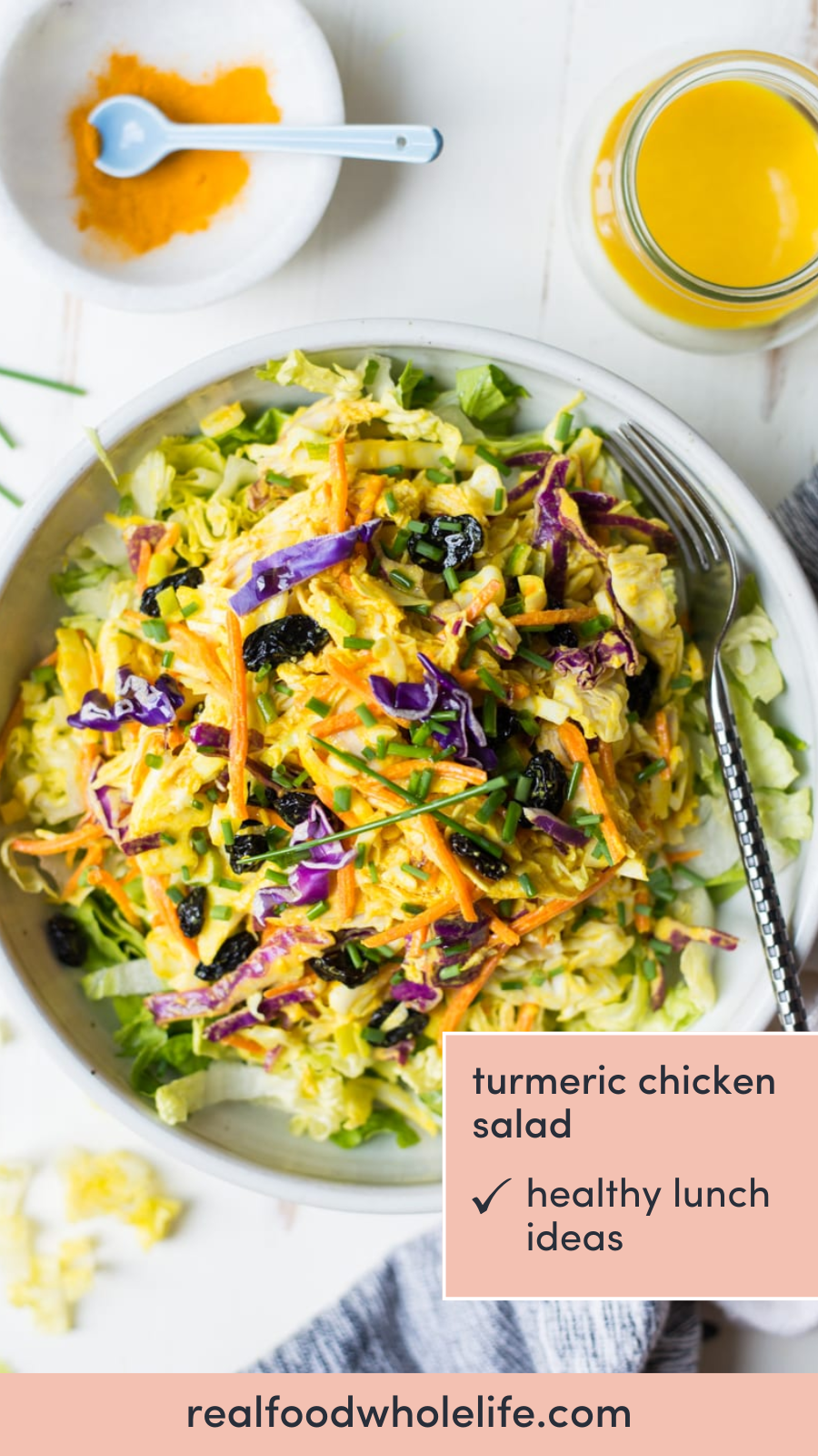 Overhead shot of a bowl of salad with a fork in it. There are containers with ground turmeric and oil around the bowl. Text overlay that reads: turmeric chicken salad.