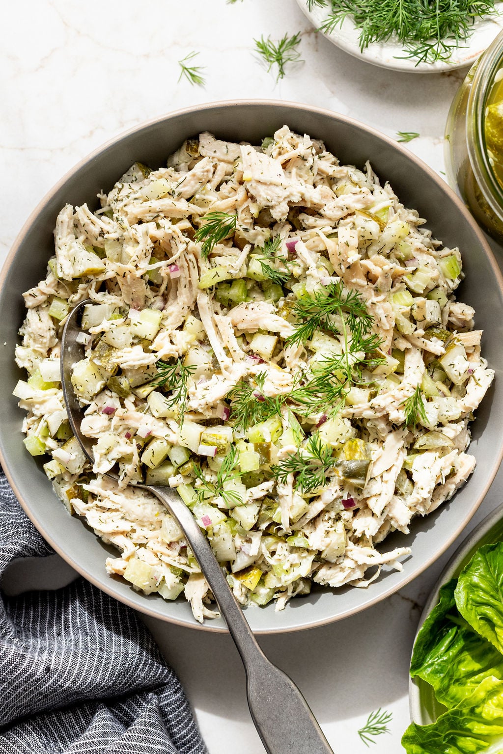 Creamy chicken salad with diced vegetables in a bowl with a spoon.