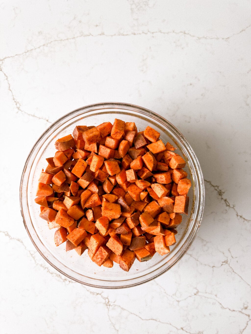 Diced sweet potatoes in a glass bowl.