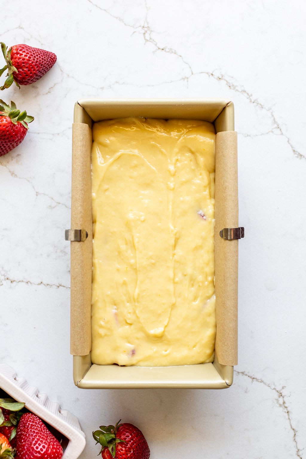 Yellow cake batter smoothed in a loaf pan.