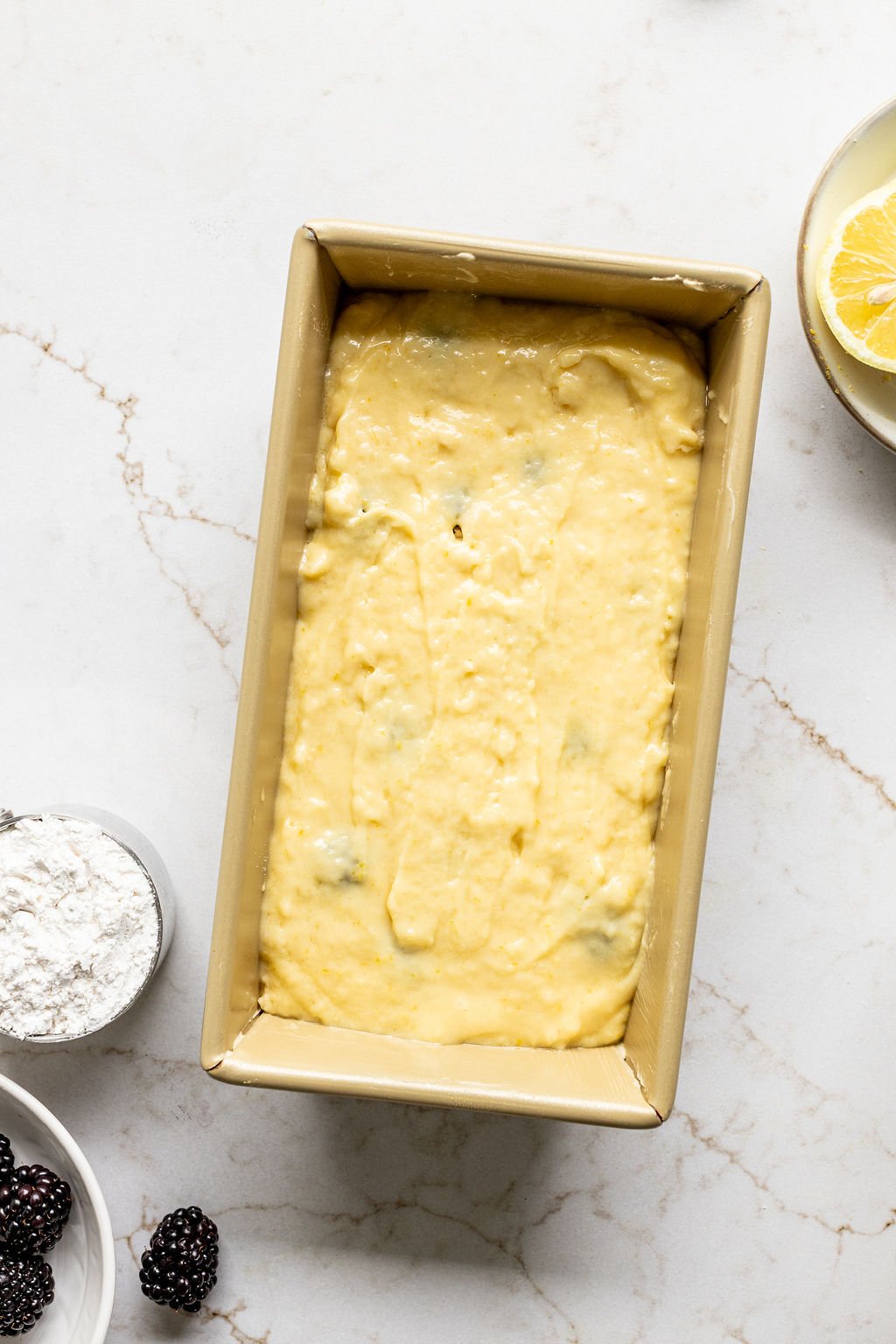 Yellow cake batter smoothed in a loaf pan.