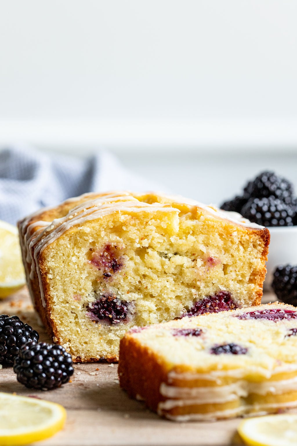 A glaze blackberry loaf cake on a wooden board.
