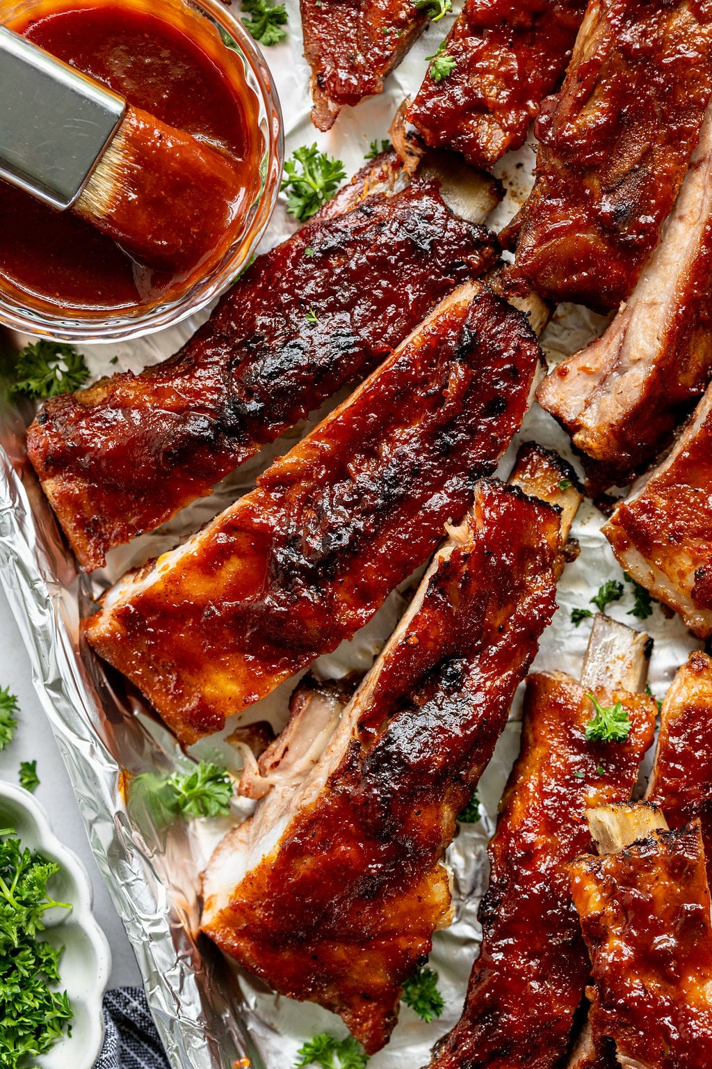 A dozen juicy, crispy pork ribs covered in barbecue sauce.