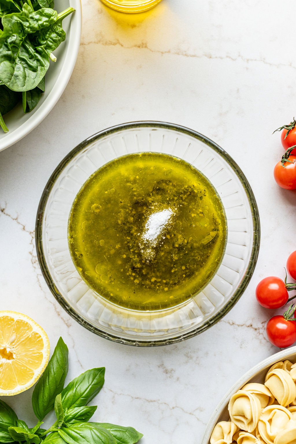 A bowl with pesto, olive oil, and salt.