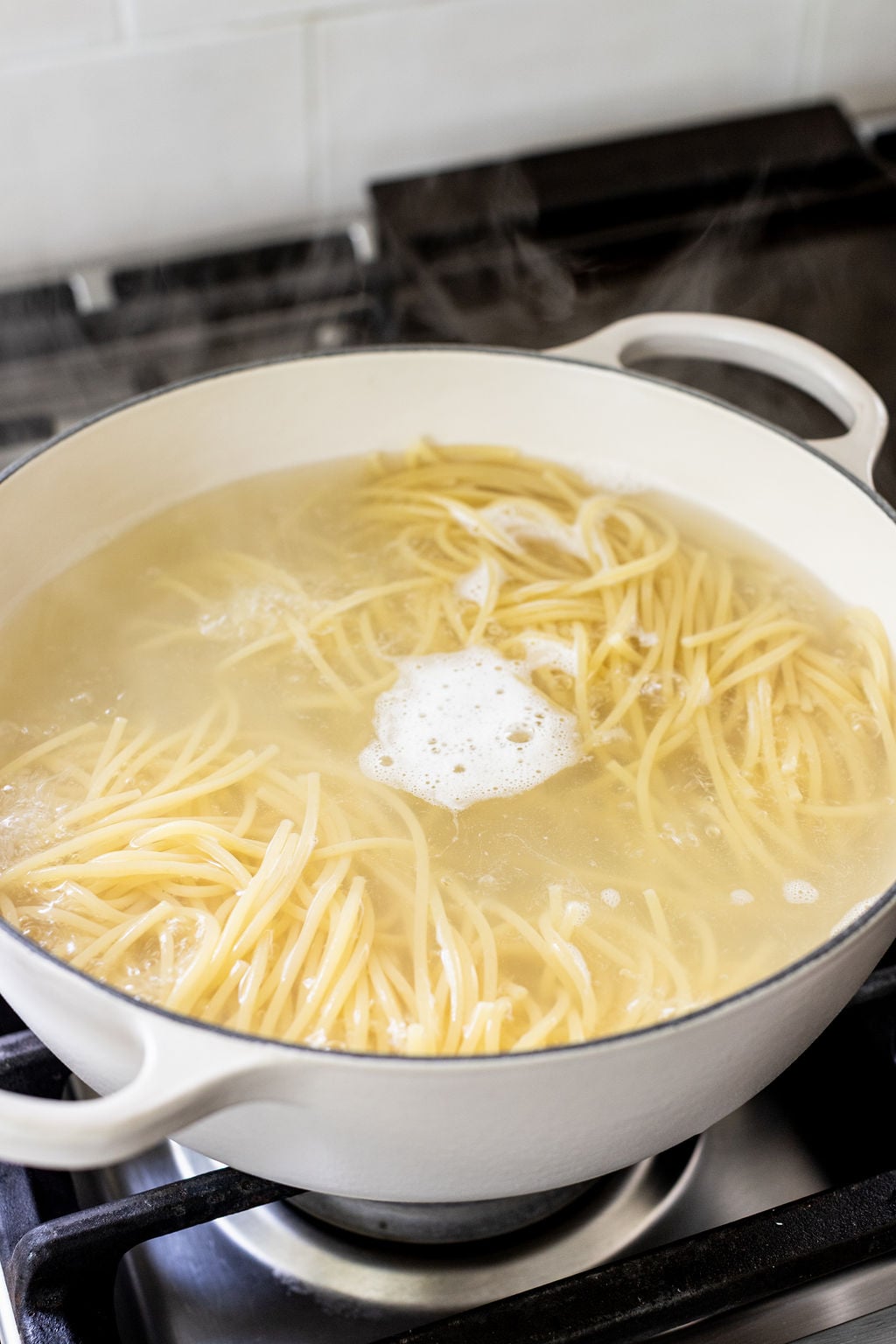 Pasta cooking in a pot on a stove.
