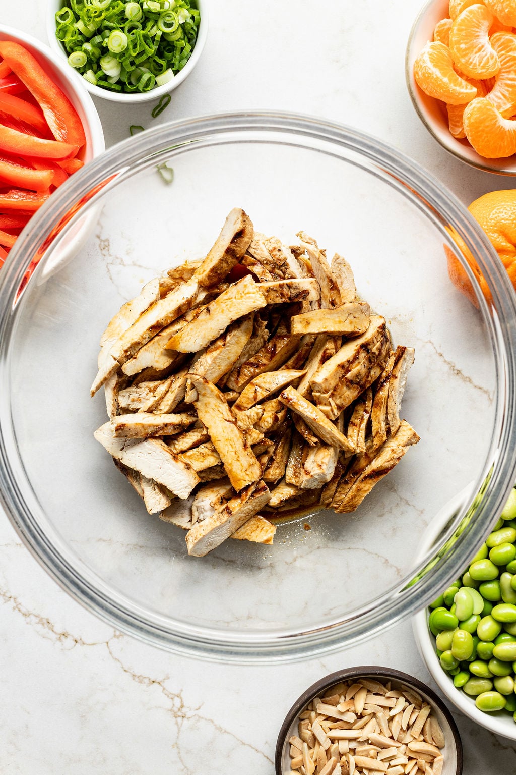 Sliced cooked chicken in a bowl.