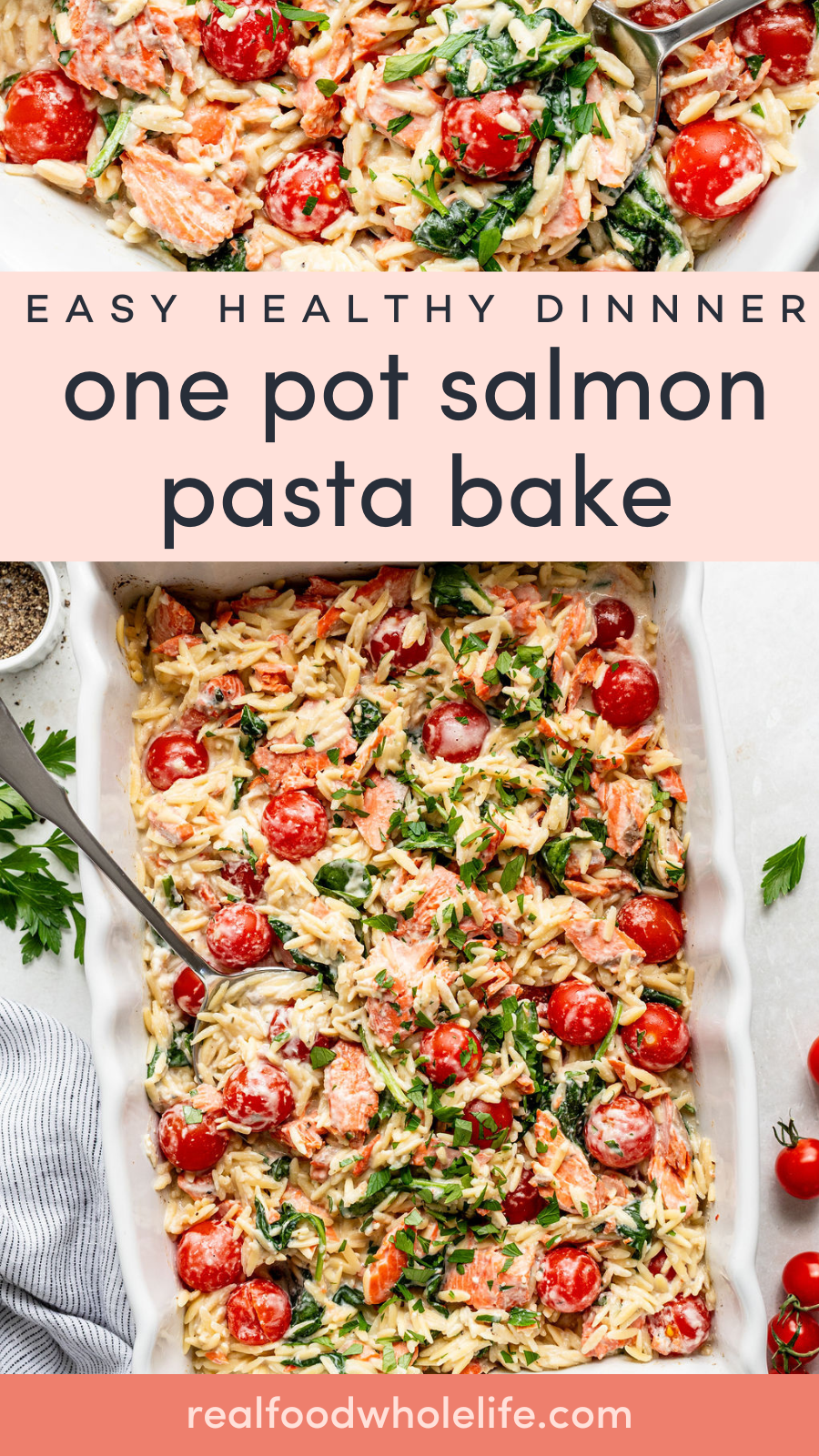 A baked pasta dish with salmon, cherry tomatoes, spinach, and herbs in a white casserole dish, with a serving spoon and parsley garnish on the side.