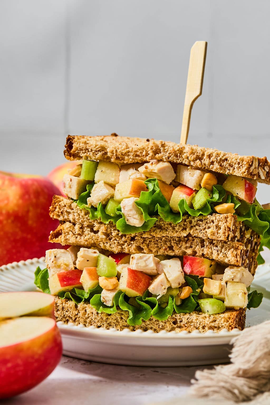 Chicken and apple salad sandwich on whole wheat bread, held together with a wooden pick.